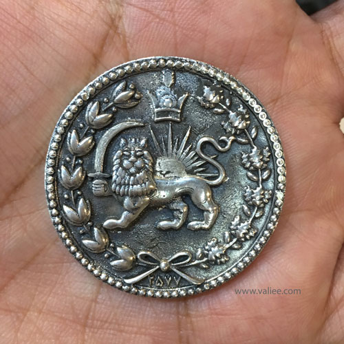 Hand-patinated silver coin featuring the Lion and Sun emblem, reinterpreted through contemporary metalwork by Mehdi Valiee